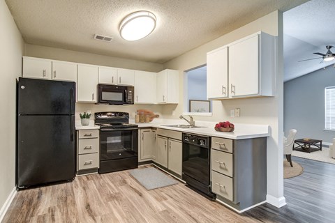 an open kitchen with black appliances and white cabinets